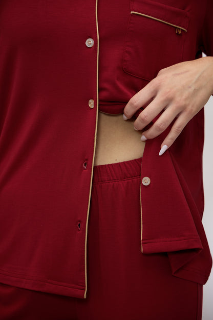Close-up of the Moon & Mare Ember Set in wine, showing the waist fit, flowing fabric, champagne piping, and matching pants.