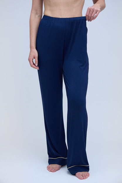 Front view of the Moon & Mare Nocturne navy pajama pants, showing the elastic waistband, relaxed leg fit, and champagne piping at the hem.